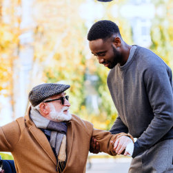 caregiver helping an elderly man get up