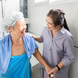caregiver helping an elderly woman take a bath